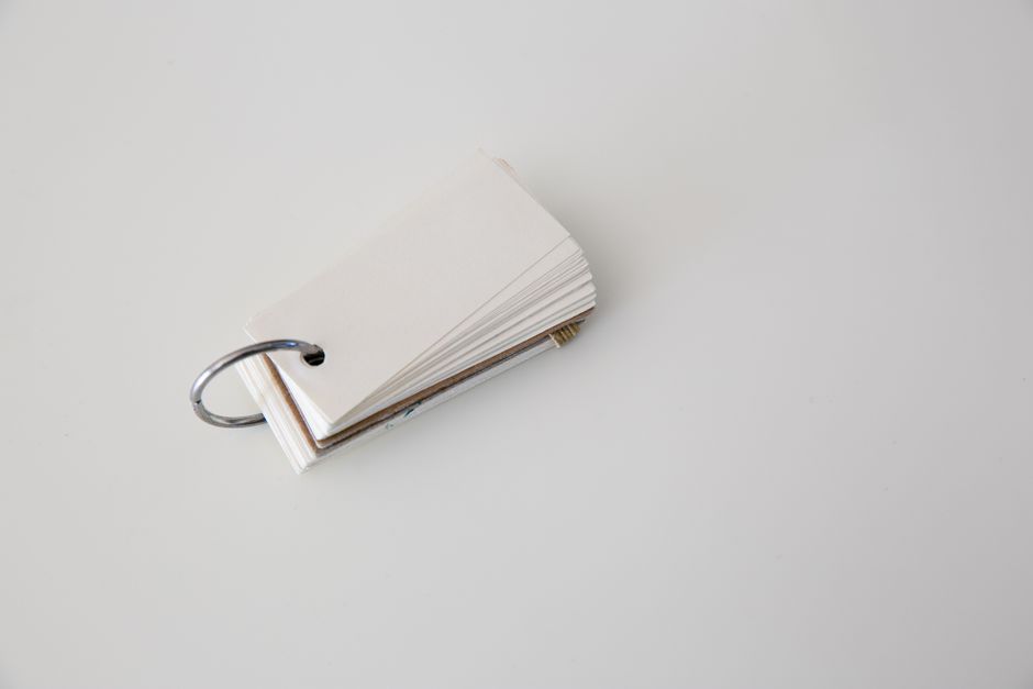 Blank flashcards on a white background held together by a metal ring, perfect for study or organization.